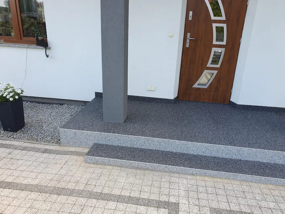 Taras z kamiennym dywanem przy nowoczesnym domu