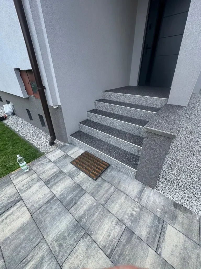 Schody wejściowe z kamiennym dywanem przy domu